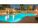 Community pool with gazebo and rock waterfall feature illuminated at night at 2929 W Yorkshire Dr # 2118, Phoenix, AZ 85027