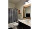 Bathroom featuring a black and white shower curtain and wooden framed mirror at 29908 W Monterey Dr, Buckeye, AZ 85396