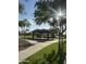Serene park view featuring a covered picnic area with tables, surrounded by lush green grass and shady trees at 29908 W Monterey Dr, Buckeye, AZ 85396