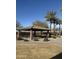 Open-air picnic pavilion with stone pillars and a tiled roof provides a shaded area for outdoor dining in the park at 29908 W Monterey Dr, Buckeye, AZ 85396