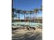 Water park area features colorful spray poles, benches, and picnic tables surrounded by palm trees under a clear blue sky at 29908 W Monterey Dr, Buckeye, AZ 85396