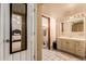 Modern bathroom with a vanity and well-lit mirror, adjacent to a well decorated bedroom at 3137 W Baseline Rd, Laveen, AZ 85339