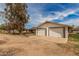 Detached two-car garage with white doors and ample parking space at 3137 W Baseline Rd, Laveen, AZ 85339