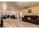 Spacious living room featuring neutral carpet, a brown sofa and access to the dining area at 3137 W Baseline Rd, Laveen, AZ 85339