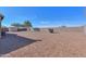 Gravel back yard features a storage shed and perimeter wall at 40314 W Marion May Ln, Maricopa, AZ 85138