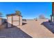 A fully fenced backyard with gravel landscaping and storage shed at 40314 W Marion May Ln, Maricopa, AZ 85138