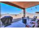 Covered backyard patio with seating and a built-in fire pit at 40314 W Marion May Ln, Maricopa, AZ 85138