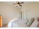 Bedroom features wood bed frame, ceiling fan and neutral walls at 40314 W Marion May Ln, Maricopa, AZ 85138