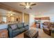 Open living room with plush sofas, neutral walls, ceiling fan, and accent furniture at 40314 W Marion May Ln, Maricopa, AZ 85138