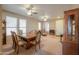 Open-concept living and dining area with carpeted floors, ceiling fans, and abundant natural light at 40314 W Marion May Ln, Maricopa, AZ 85138
