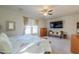 Spacious bedroom with a ceiling fan, large window, and a flat-screen TV at 40314 W Marion May Ln, Maricopa, AZ 85138