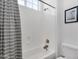 Bright bathroom featuring a shower over the tub with chrome fixtures, a window providing natural light, and toilet at 4457 E Fountain St, Mesa, AZ 85205