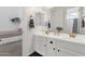 Bright bathroom featuring a double sink vanity with gold fixtures and a mirror, and view into adjacent bedroom at 4457 E Fountain St, Mesa, AZ 85205