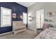 Stylish Bedroom with blue accent wall, crib, decorative shelving and chair, offering a cozy and inviting space at 4457 E Fountain St, Mesa, AZ 85205