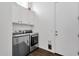 Convenient laundry room with front load washer and dryer, white cabinets, providing ample storage and functionality at 4457 E Fountain St, Mesa, AZ 85205