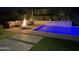 Backyard at night featuring a swimming pool and a comfortable seating area around a fire pit at 4457 E Fountain St, Mesa, AZ 85205