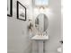 Elegant powder room featuring a pedestal sink, gold fixtures, and stylish decor for guests at 4457 E Fountain St, Mesa, AZ 85205