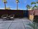 Backyard featuring patio with chair seating, brick fence, garden hose, blue sky and palm trees at 4750 N Central Ave # 1N, Phoenix, AZ 85012