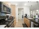 Well-equipped kitchen with light wood cabinets, black countertops, and modern stainless steel appliances at 5100 E Rancho Paloma E Dr # 1046, Cave Creek, AZ 85331