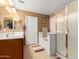 Bathroom featuring double sinks, shower, bathtub, tile floors, and wood cabinets at 5749 S 249Th Dr, Buckeye, AZ 85326