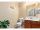 Cozy half bathroom features wood cabinets and a standard toilet at 5749 S 249Th Dr, Buckeye, AZ 85326