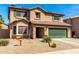 Charming two-story home with desert landscaping, a tile roof, and a green garage door at 5749 S 249Th Dr, Buckeye, AZ 85326