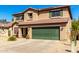 Two-story home with desert landscaping, a green garage door, a tile roof and solar panels at 5749 S 249Th Dr, Buckeye, AZ 85326