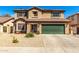 Charming two-story home with a green garage door, desert landscaping, and a tile roof at 5749 S 249Th Dr, Buckeye, AZ 85326