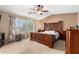 Bedroom featuring carpeted floors, ceiling fan and a large bed frame with curtains at 5749 S 249Th Dr, Buckeye, AZ 85326