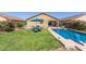 Exterior of a home showcasing a pristine yard, patio set with a blue umbrella, and an inviting swimming pool at 581 W Angus Rd, San Tan Valley, AZ 85143