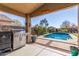 Outdoor kitchen with a built-in BBQ and view of the sparkling backyard pool at 581 W Angus Rd, San Tan Valley, AZ 85143