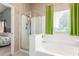 Bright bathroom featuring a soaking tub and glass-enclosed shower at 581 W Angus Rd, San Tan Valley, AZ 85143