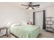 Bright bedroom with a ceiling fan, a green patterned bedspread and accent chair at 581 W Angus Rd, San Tan Valley, AZ 85143