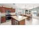 Open-concept kitchen with island, dining area, and a view of the living room and backyard at 581 W Angus Rd, San Tan Valley, AZ 85143
