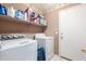 Functional laundry room featuring a washer, dryer and built-in storage shelves at 581 W Angus Rd, San Tan Valley, AZ 85143