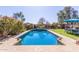 Inviting pool with clear blue water, surrounded by lush landscaping and patio seating area, perfect for outdoor relaxation at 581 W Angus Rd, San Tan Valley, AZ 85143