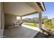 Enjoy outdoor relaxation on the large, shaded patio with a table, lush garden, and artificial turf at 5854 S Del Rancho --, Mesa, AZ 85212