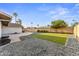 Landscaped backyard featuring turf, rock features, and a view of palm trees at 6134 E Hannibal St, Mesa, AZ 85205