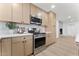Kitchen with stainless steel appliances, view of fireplace, and natural wood cabinets at 6134 E Hannibal St, Mesa, AZ 85205