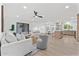 Open-concept living room with white sofas, an island kitchen, and light wood flooring at 6134 E Hannibal St, Mesa, AZ 85205