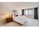 Comfortable main bedroom featuring soft lighting, a plush bed, and a large window with a view at 7960 E Camelback Rd # 209, Scottsdale, AZ 85251