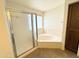 Bathroom featuring a bathtub with sliding glass shower doors and a window for natural light at 8217 E Medina Ave, Mesa, AZ 85209