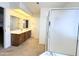 Well-lit bathroom with a vanity, large mirror, and bathtub with sliding shower doors at 8217 E Medina Ave, Mesa, AZ 85209