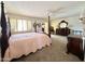 Large main bedroom featuring a ceiling fan, neutral carpet, plantation shutters, and room for a sitting area at 8217 E Medina Ave, Mesa, AZ 85209