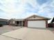 Suburban brick home boasts a wide driveway leading to an attached two-car garage, offering ample parking at 8217 E Medina Ave, Mesa, AZ 85209