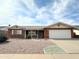 Charming brick home featuring a two-car garage and well-kept landscaping, perfect for suburban living at 8217 E Medina Ave, Mesa, AZ 85209