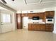 Shows a kitchen with lots of wood cabinets, older appliances, and a door to the exterior at 8217 E Medina Ave, Mesa, AZ 85209