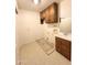 Features a utility sink with storage, upper cabinets and beige flooring in the laundry room at 8217 E Medina Ave, Mesa, AZ 85209