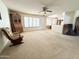Open living area with neutral carpet, a ceiling fan, lots of windows and a view to the kitchen at 8217 E Medina Ave, Mesa, AZ 85209