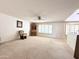 Open and airy living room shows a ceiling fan, hutch and view to the kitchen and breakfast nook at 8217 E Medina Ave, Mesa, AZ 85209